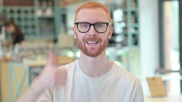 Portrait of Thumbs Up By Hopeful Redhead Man