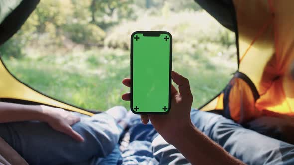Handheld Firstperson View Man Using a Smartphone While Lying in a Tent Chroma Key Template Outdoor