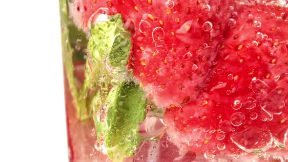 Appetizing Refreshment Strawberry Cocktail with Mint Fizzy Bubbles Rotating in Glass Macro Closeup