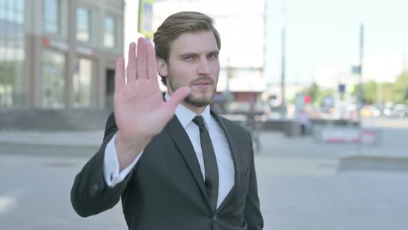 Stressed Young Businessman Showing Stop Gesture Outdoor