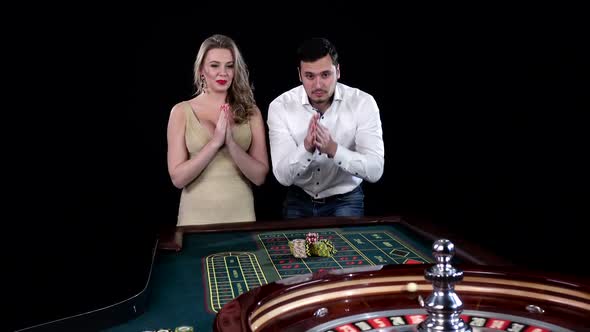 Young Man and Woman Gambling at Poker Table. Black