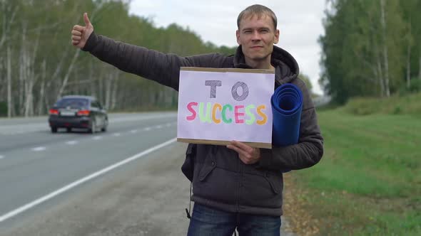 Hitchhiking Man Holding a Cardboard Sign