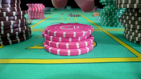 Camera Pans Over Green Gaming Table with Stacks of Casino Chips on Black Background
