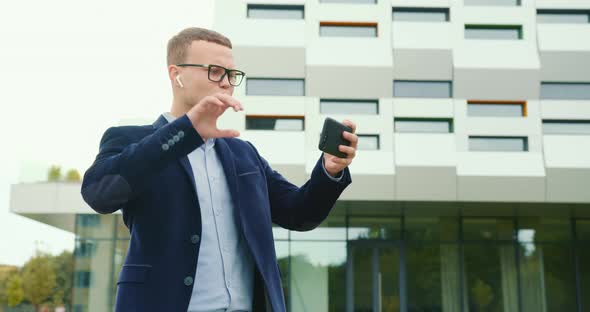 A Businessman Is Walking Near the Business Center and Discontentedly Talking Via Video