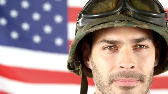 Soldier standing in front of American flag