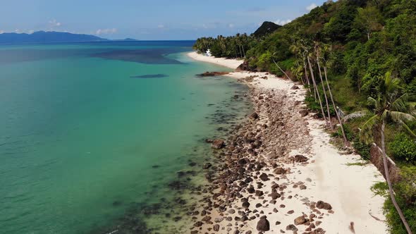 Green Jungle and Stony Beach Near Sea. Tropical Rainforest and Rocks Near Calm Blue Sea on White