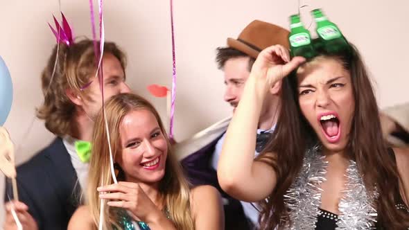 Funny couples playing with props in party photo booth