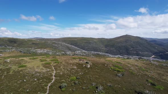 drone video sweeping around some mountain bikers on top of a mountain peak.