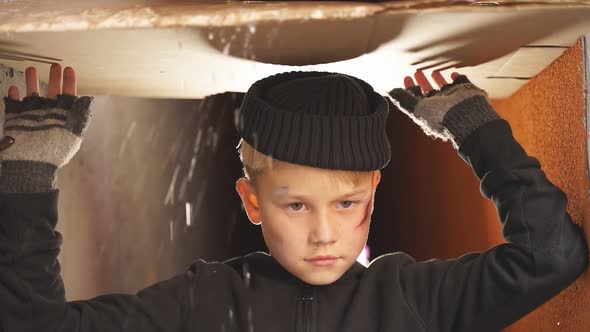 Homeless Boy Uses Cardboard To Shelter From the Rain