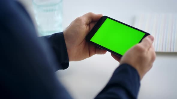 Close Up Man Hands Holding Smartphone with Green Screen. Male Looking Cell Phone
