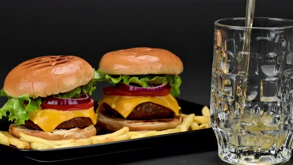 Tasty burgers with french potatoes a mug of beer