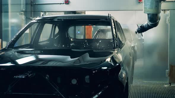 Factory Machine Is Spraying Zinc Over a Carcass of a Car