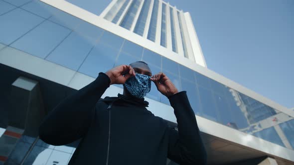 African American Man Out and About in the City Streets During the Day, Wearing a Face Mask Against