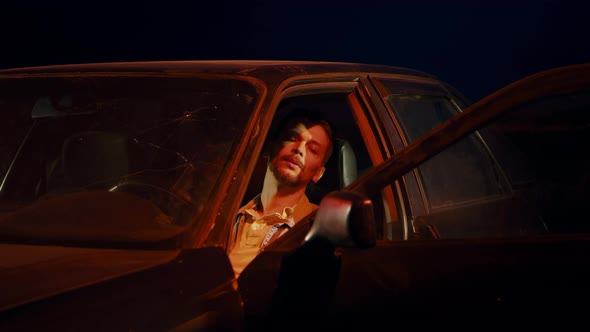 Man Sits at Night in a Car Thinks About Something Worries