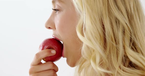 Close-up of beautiful woman eating red apple