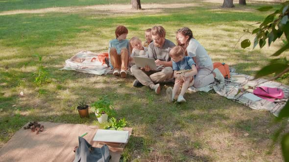 Sequence of Teacher and Kids Looking at Laptop in Park