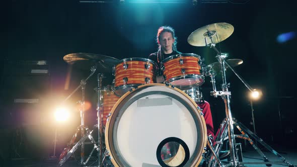 A Musician with Dreadlocks Is Playing Drums. Male Drummer Playing Drums in Smoke