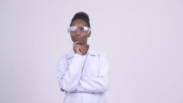 Young Happy African Woman Doctor with Protective Glasses Thinking