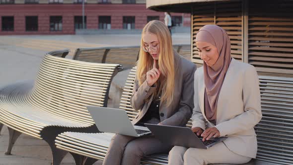 Two Diverse Confident Smiling Colleagues Indian Girl in Hijab and Young Scandinavian European Woman