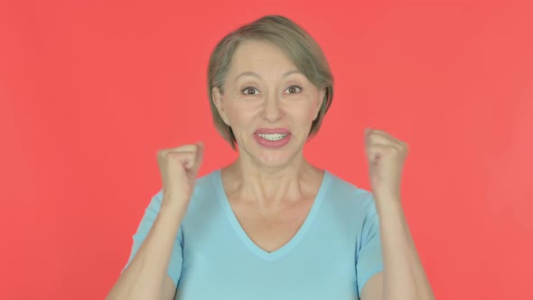 Successful Old Woman Celebrating on Red Background