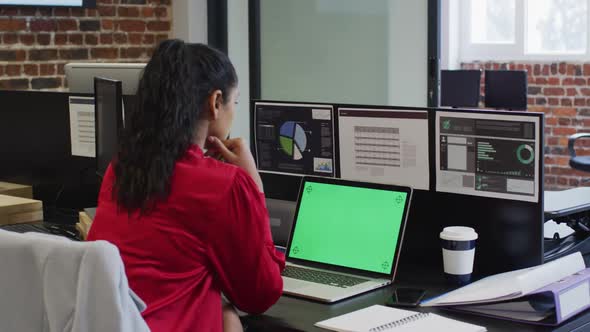 Woman using laptop while sitting on her desk at office