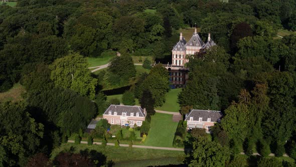 Majestic castle of Duivenvoorde surrounded by green forestry landscape, aerial view