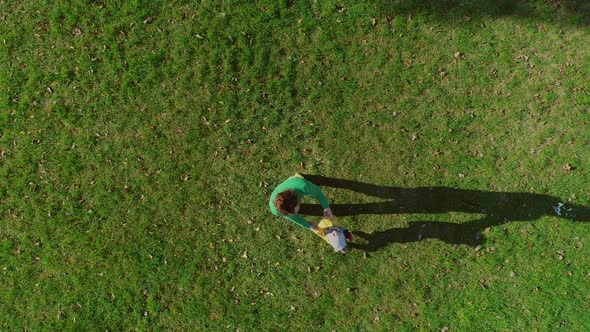 Aerial view of father rotating infant son at public playground, Zagreb, Croatia.