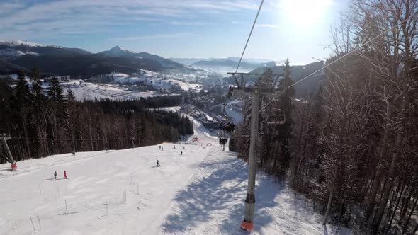 POV From Ski Chair Lift To Snowy Ski Slope, Skiers Slide on Ski Slope.Ski Resort