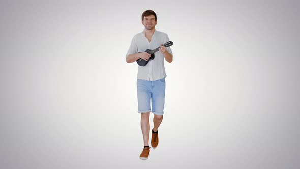 Young Man Playing Ukulele While Walking on Gradient Background