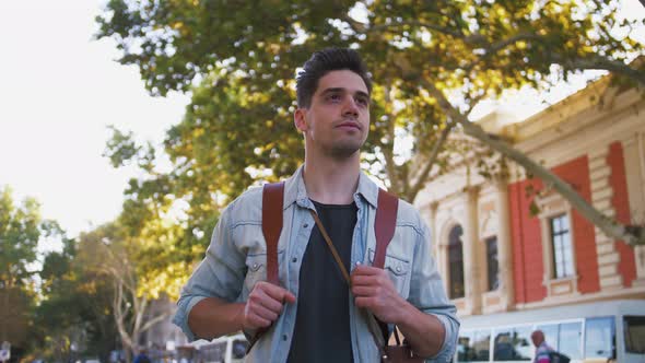 Portrait of Young Attractive Handsome Man Tourist with Backpack in City Center Slow Motion Low Angle