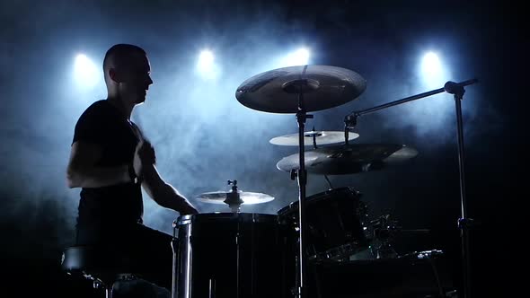 Musician Plays a Melody on the Drums, Black Smoke Background, Side View, Silhouettes, Slow Motion