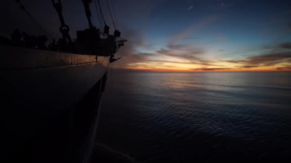 view the side of a boat when it's cruising through a galssy water surface in the sunset. shot with S