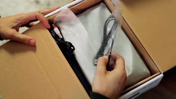 Man Opening a Box containing a Digital TV Decoder for Home Entertainment.