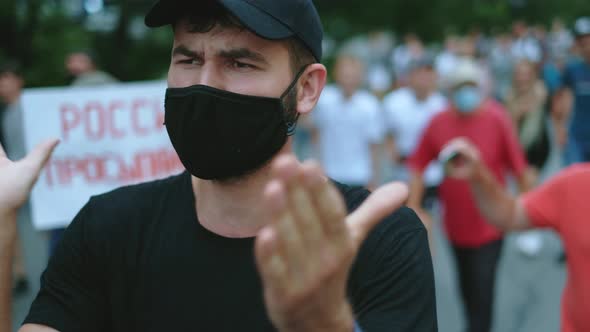 Masked revolutionary rebel guy claps and applauds in street picket crowd strike.