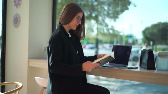 Serious woman writing in notebook during remote work