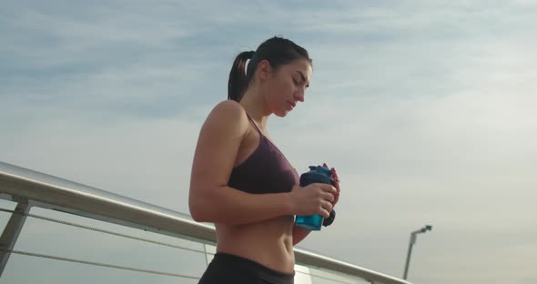 Female Athlete Drinking Water During Break