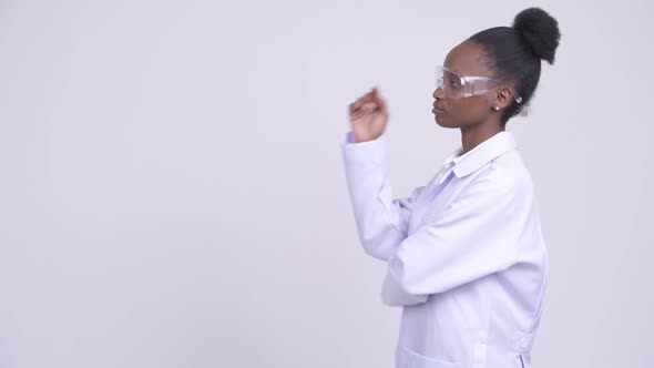 Profile View of Young African Woman Doctor with Protective Glasses Thinking