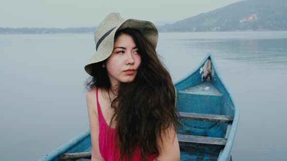 Asian woman swims in the kayak in the sunset