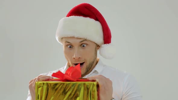 Portrait of a beautiful man in Santa's hat with a fun face image, white background.