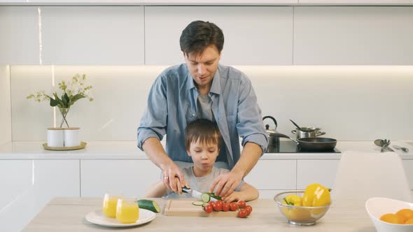 Man and His Son Are Cutting Vegetables