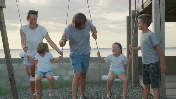 Big Cheerful Family Having Fun on a Swing.