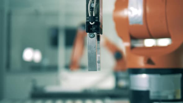 Metal Claw of a Mechanical Robot Grabbing a Cube