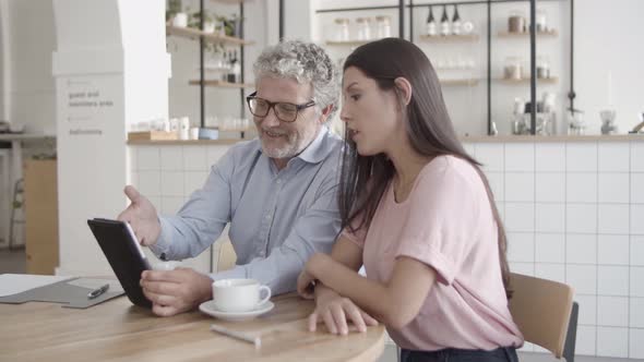 Content Boss Pointing at Tablet Screen with Finger and Showing