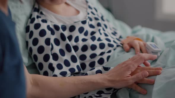 Mother Holding Sick Daughter Hands After Sufffering Medical Surgery During Recovery Examination