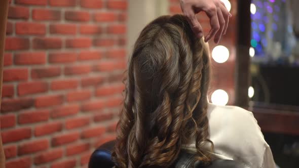 Long Brown Hair Curls with Hairdresser Spraying Fixation Spray in Slow Motion