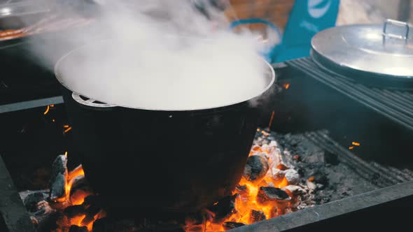 Big Vat of Hot Food Is Cooked on the Coals on a Street Christmas Market