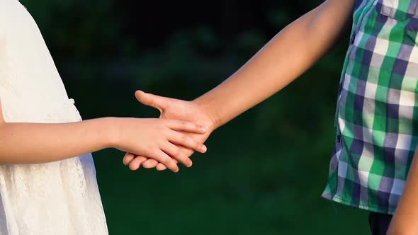 Boy Tenderly Taking Little Girl Hand, Shyly Looking in Her Eyes, First Love