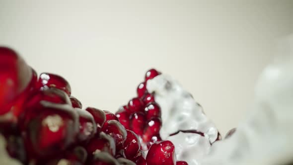 Motion Above Pieces of Pomegranate Fruit on Light Background