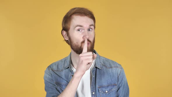 Redhead Man Gesturing Silence Finger on Lips Yellow Background