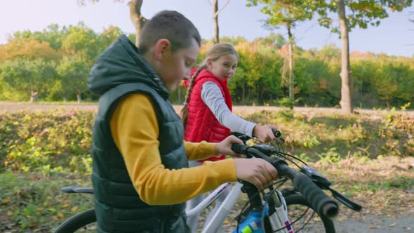 Children Walking in the Woods with Bicycles